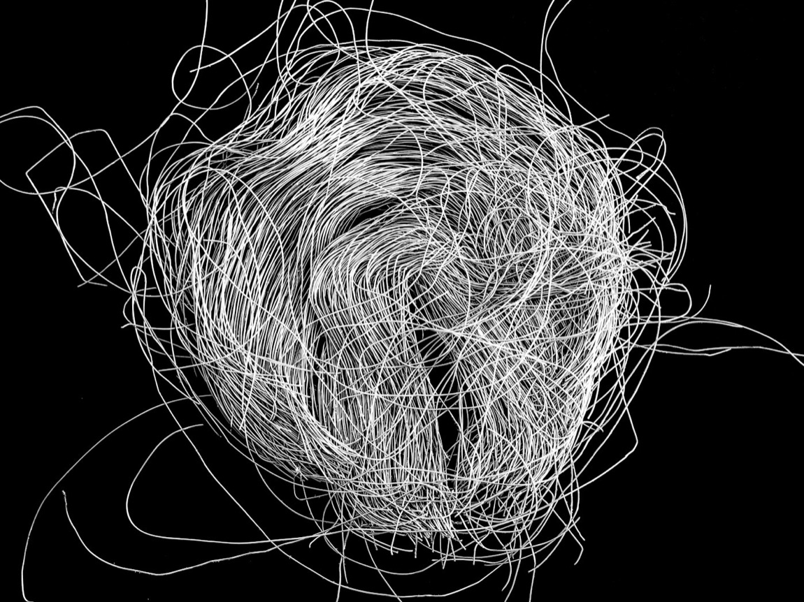 A chaotic tangle of white cables on a black background, the universal symbol of a hard-to-debug failure